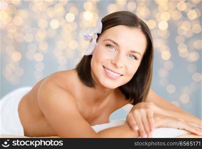 wellness and beauty concept - close up of beautiful woman at spa over holidays lights background. close up of beautiful woman at spa