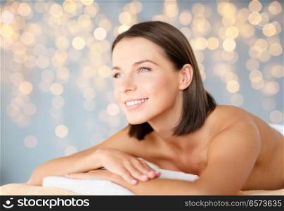 wellness and beauty concept - close up of beautiful woman at spa over holidays lights background. close up of beautiful woman at spa