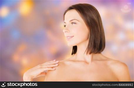wellness and beauty concept - portrait of beautiful bare woman over holidays lights background. beautiful bare woman over green natural background. beautiful bare woman over green natural background