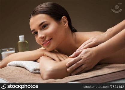 wellness, beauty and relaxation concept - beautiful young woman lying and having massage at spa. woman lying and having massage at spa