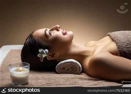 wellness, beauty and relaxation concept - young woman lying at spa or massage parlor. young woman lying at spa or massage parlor