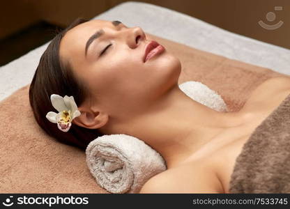 wellness, beauty and relaxation concept - young woman lying at spa or massage parlor. young woman lying at spa or massage parlor