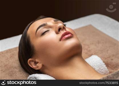 wellness, beauty and relaxation concept - young woman lying at spa or massage parlor. young woman lying at spa or massage parlor