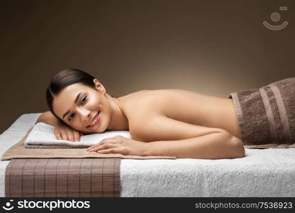 wellness, beauty and relaxation concept - young woman lying at spa or massage parlor. young woman lying at spa or massage parlor