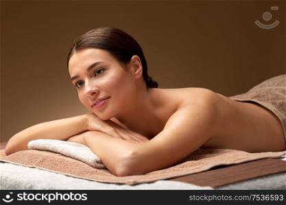 wellness, beauty and relaxation concept - young woman lying at spa salon or massage parlor. young woman lying at spa salon or massage parlor