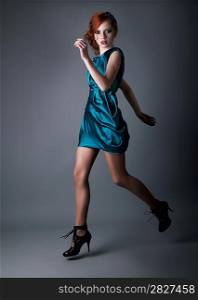 wellness - healthy young active girl running in blue dress. Studio shot