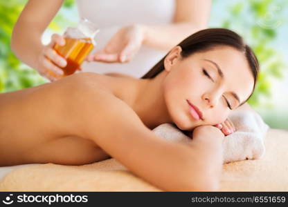 wellness, spa and beauty concept - close up of beautiful woman having massage over green natural background. close up of beautiful woman having massage at spa. close up of beautiful woman having massage at spa