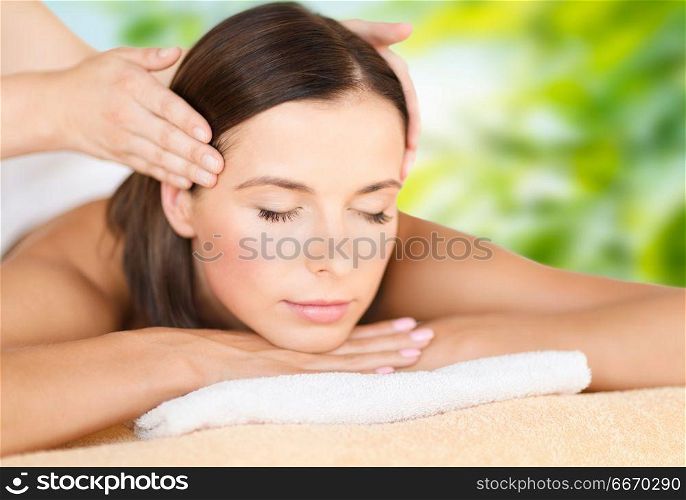 wellness, spa and beauty concept - close up of beautiful woman having head massage over green natural background. close up of beautiful woman having head massage. close up of beautiful woman having head massage