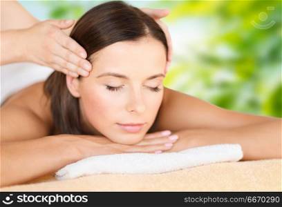 wellness, spa and beauty concept - close up of beautiful woman having head massage over green natural background. close up of beautiful woman having head massage. close up of beautiful woman having head massage