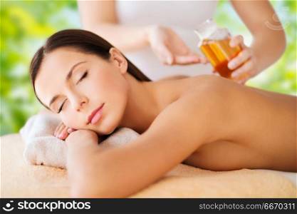 wellness, spa and beauty concept - close up of beautiful woman having massage over green natural background. close up of beautiful woman having massage at spa. close up of beautiful woman having massage at spa
