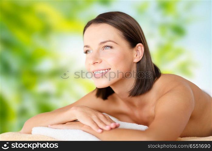 wellness, spa and beauty concept - close up of beautiful woman over green natural background. close up of beautiful woman at spa. close up of beautiful woman at spa