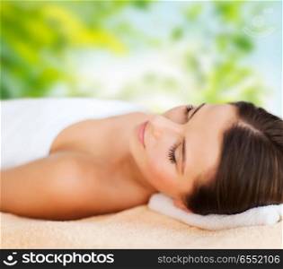 wellness, spa and beauty concept - close up of beautiful woman over green natural background. close up of beautiful woman at spa. close up of beautiful woman at spa