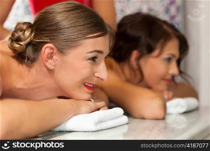 Wellness - two young women, presumably friends, getting a massage in their vacation