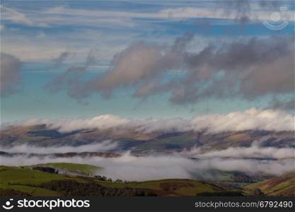 Welsh countryside with cloud clinging to hills in temperature inversion. Powys, Wales, United Kingdom.