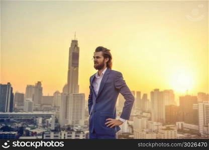 Western businessman looking at Bangkok city at sunset