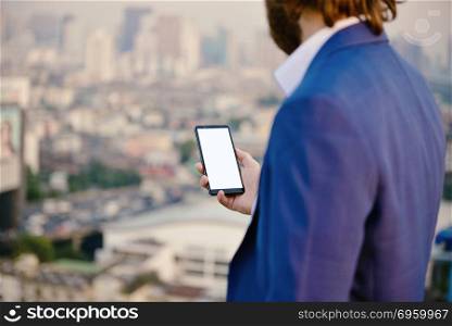 Western businessman using a smartphone with blank screen isolate. Western businessman using a smartphone with blank screen isolated with city background. Western businessman using a smartphone with blank screen isolated with city background