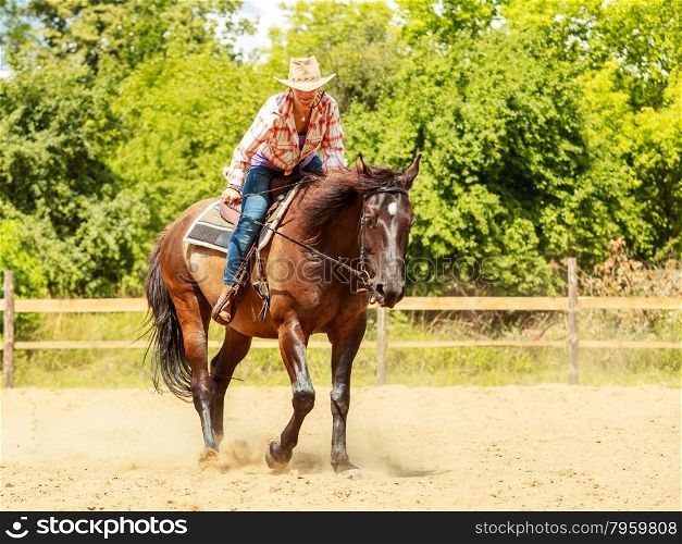 Western cowgirl woman riding horse. Sport activity. Active western cowgirl woman in hat training riding horse. American girl in countryside ranch. Horseback sport activity.