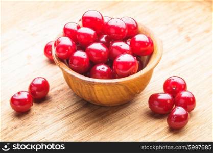 Wet cherries fruits close up in a wooden bowl. Cherries close up