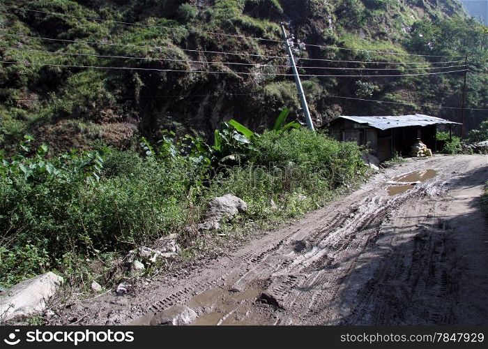 Wet dirt road and hut in mountain in NEpal