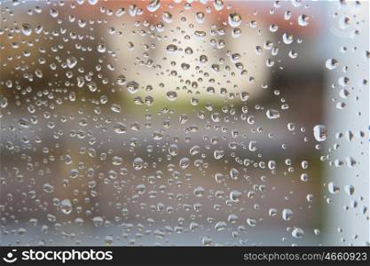 Wet glass with drops of rain fall on the street,