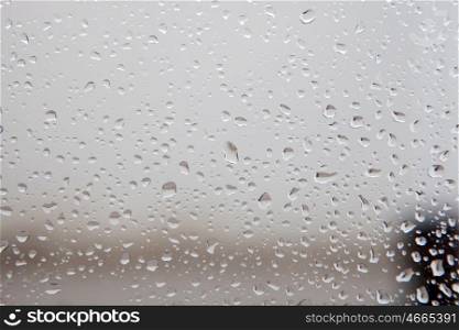 Wet glass with drops of rain fall on the street,