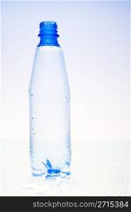 Wet plastic water bottle with water drops