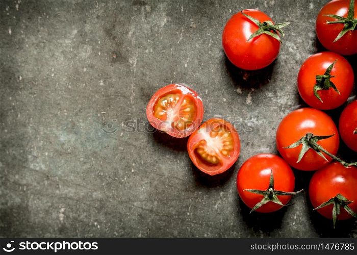 Wet red tomatoes on the stone table.. Wet tomatoes on stone table.