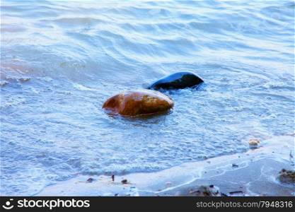 Wet stones in the water, near the beach, horizontal image
