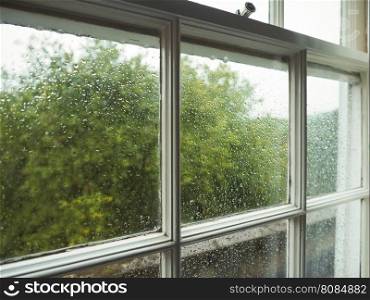 Wet window pane. Wet window pane with rain water droplets and greenery background