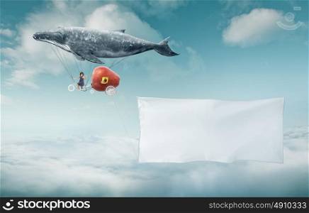 Whale floats in the sky with a happy sister and carrying a blank white banner with a copy space area.