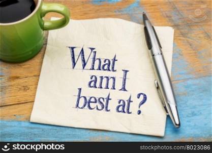 What am I best at? Handwriting on a napkin with cup of coffee against gray slate stone background