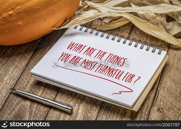What are the things you are most thankful for? Inspirational handwriting in a spiral sketchbook with a pumpkin and corn, Thanksgiving holiday concept