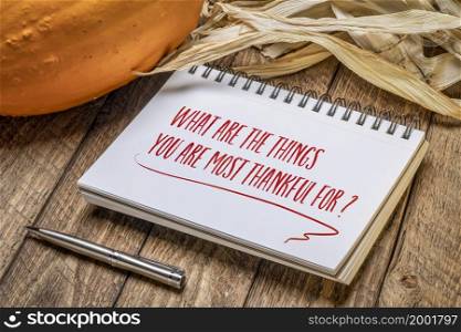 What are the things you are most thankful for? Inspirational handwriting in a spiral sketchbook with a pumpkin and corn, Thanksgiving holiday concept