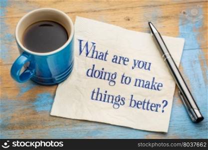 What are you doing to make things better? Handwriting on a napkin with a cup of espresso coffee