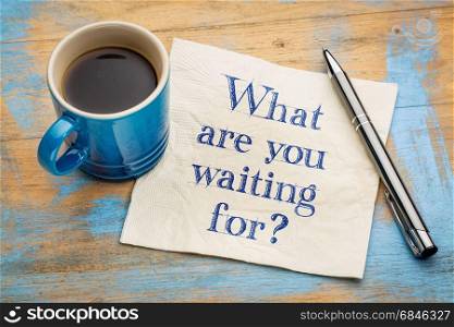 What are you waiting for question - handwriting on a napkin with a cup of espresso coffee
