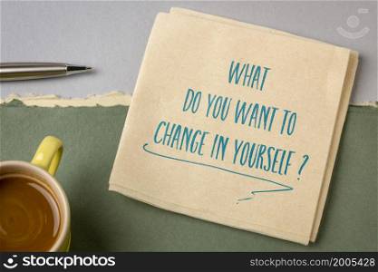 What do you want to change in yourself ? Handwriting on a napkin with coffee. Self improvement and personal development concept.