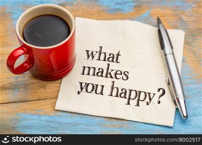What makes you happy? A question handwritten on a napkin with a cup of coffee against grunge wood