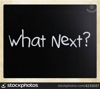 ""What Next?" handwritten with white chalk on a blackboard."