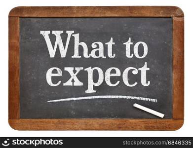 What to expect - white chalk text on a vintage slate blackboard
