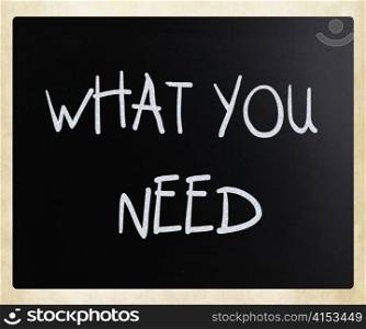 ""What you need" handwritten with white chalk on a blackboard"