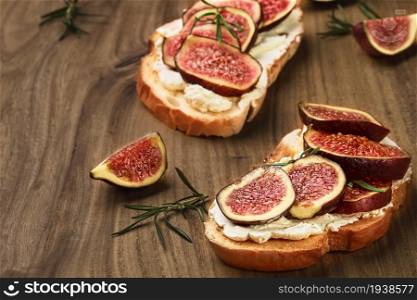 Wheat bread toast with figs and ricotta cheese on a wooden backdrop, closeup view, selective focus. Healthy food