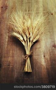 Wheat ears on wooden background
