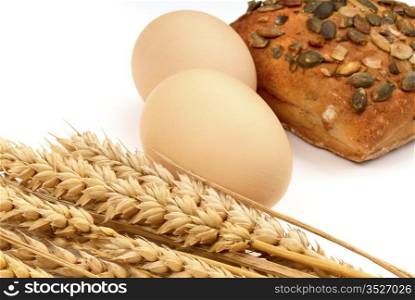 Wheat, eggs, and loaf on a white background. Macro.