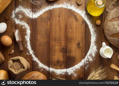 wheat flour and bakery ingredients on wooden table background