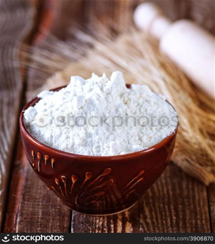 wheat flour in bowl and on a table