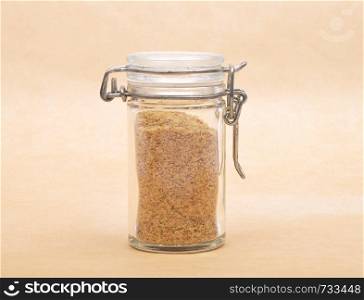 Wheat germs in closed jar on brown background
