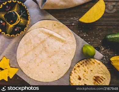 wheat mexican tortilla tasty nachos lemons wooden table with mexican hat