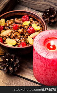 Wheat porridge with nuts and raisins. Traditional Christmas porridge, kutya and lighted candle