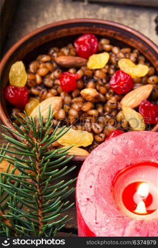 Wheat porridge with nuts and raisins. Traditional Christmas porridge, kutya and lighted candle