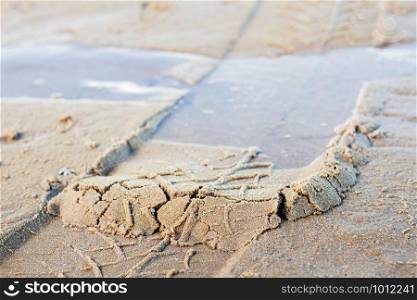 Wheel marks on sand at the sea with background.